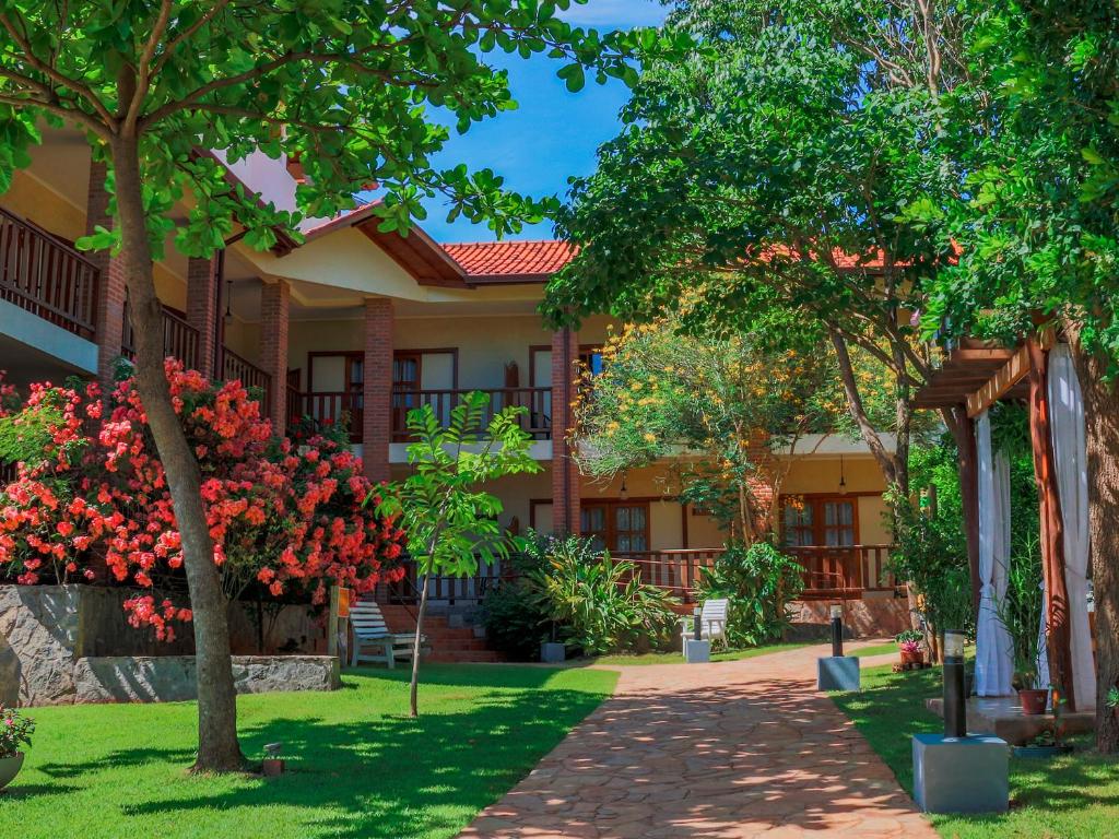 a building with trees and a walkway in front of it at Pousada Girassol in Bonito