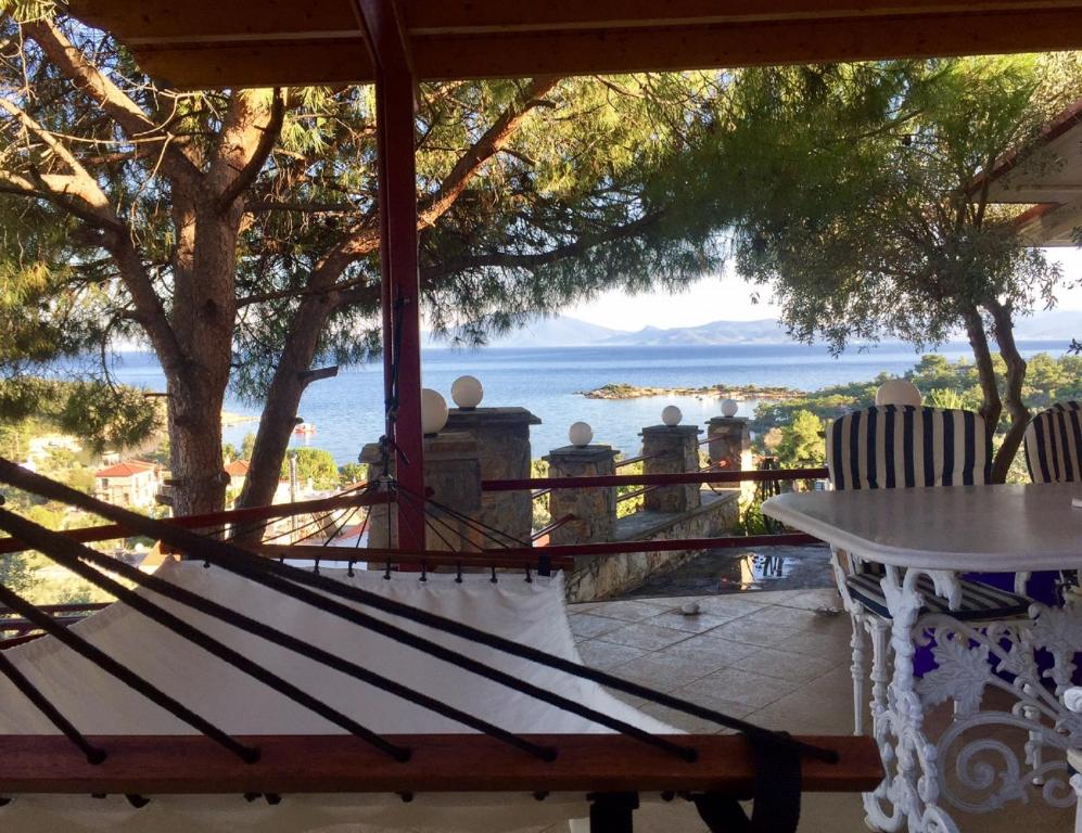 a bench on a porch with a view of the ocean at Alexander's in Kritharia