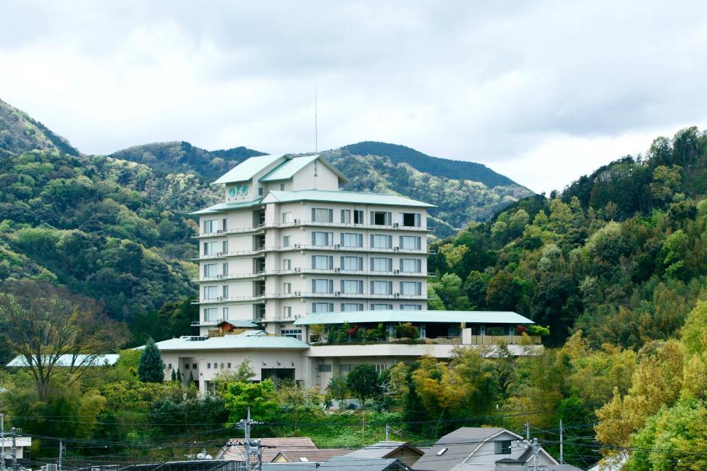 un gran edificio blanco frente a una montaña en Izu-Nagaoka Hotel Tenbo, en Izunokuni