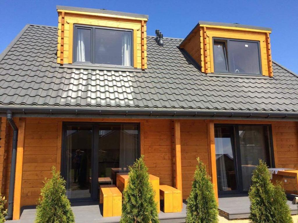 a wooden house with windows and a roof at Domki letniskowe La Familia in Sianozety