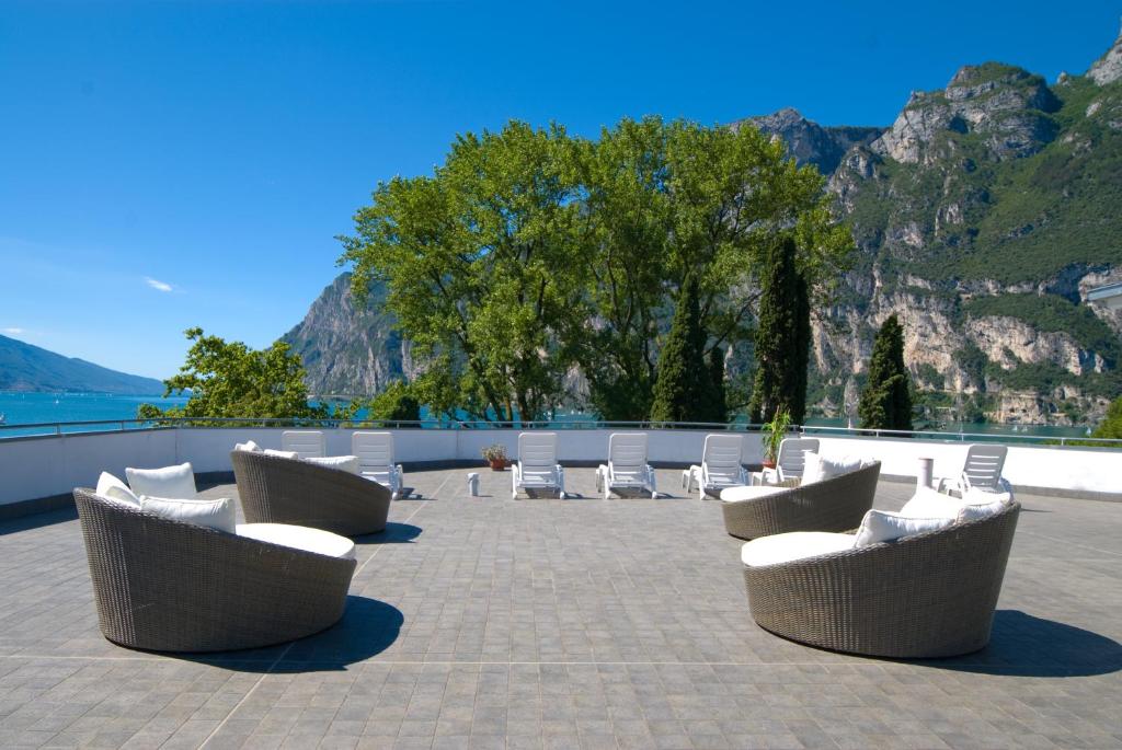 um grupo de cadeiras e mesas num pátio em Hotel Oasi Wellness & Spa em Riva del Garda