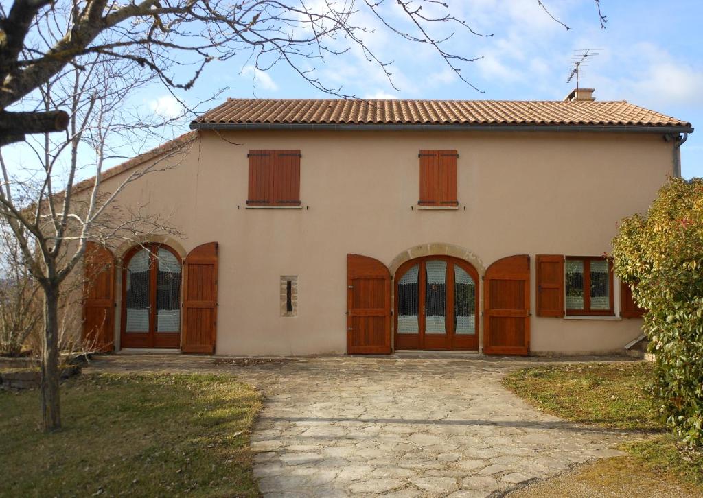 una grande casa con porte e finestre in legno di La Jasse De Blayac a Roquefort-sur-Soulzon