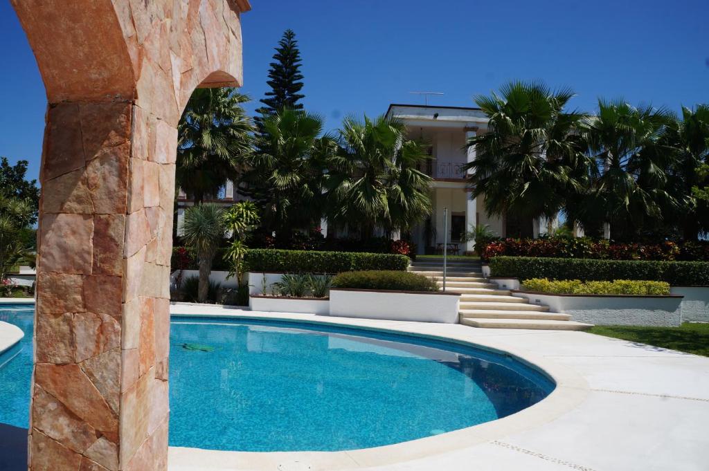 a swimming pool in front of a building with palm trees at Finca Garullo Hotel Boutique in San Rafael