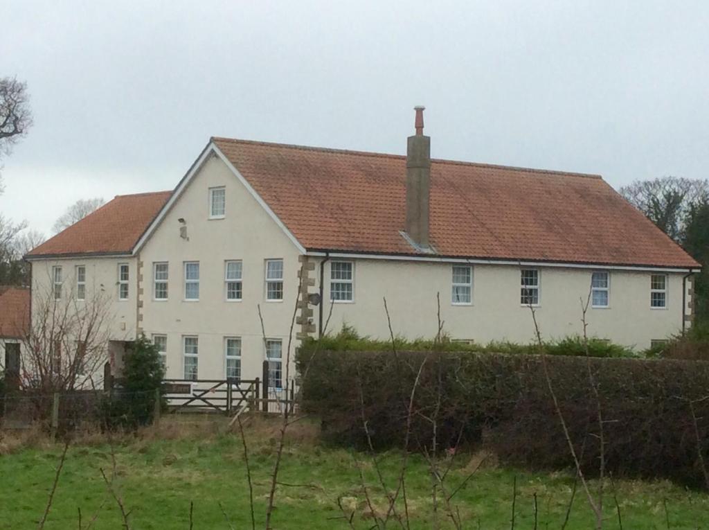 a large white house with a brown roof at Mill Farm B&B in Great Ayton