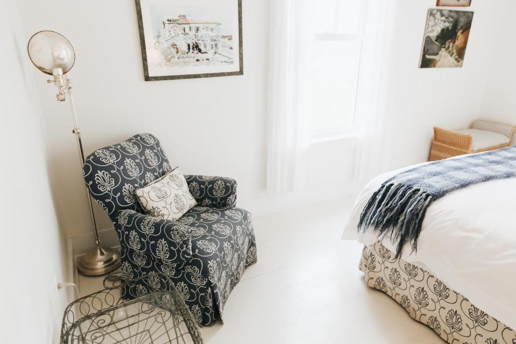 a bedroom with a chair and a bed at Chebeague Island Inn in Royal Junction