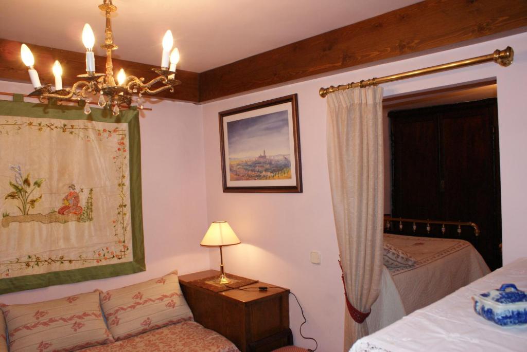 PrádenaにあるCasa Rural El aceboのベッドルーム1室(ベッド1台、シャンデリア付)