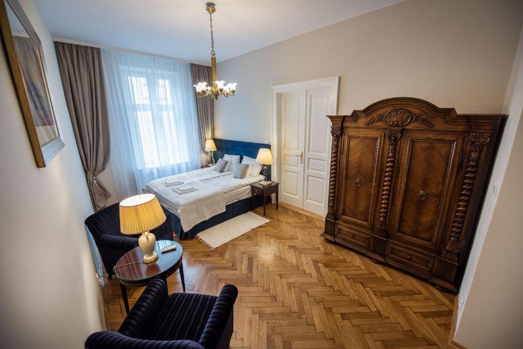 sypialnia z łóżkiem i dużą drewnianą szafką w obiekcie MJZ Apartments Old Town Krakow w Krakowie