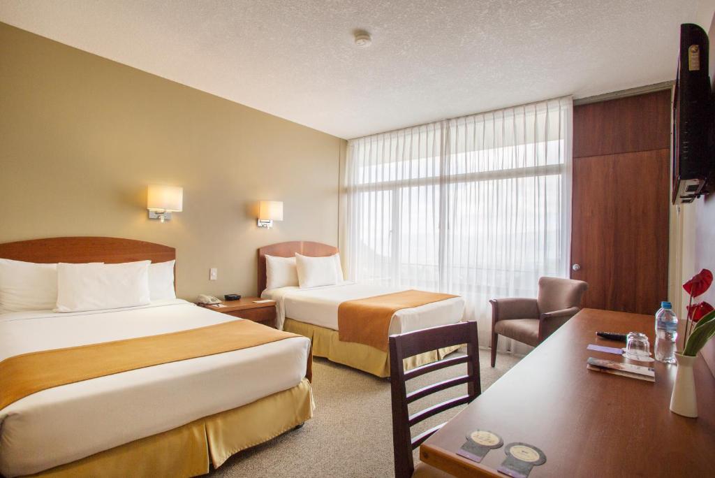 Postel nebo postele na pokoji v ubytování Hotel Quito