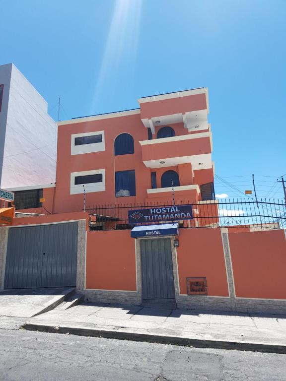 un edificio arancione con un cartello di fronte di Hostal Tutamanda 2 a Quito