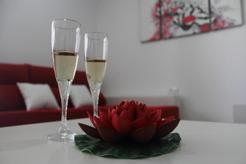 アルゴドナレスにあるBe Happyのワイン2杯とテーブルの上に飾られた赤い花