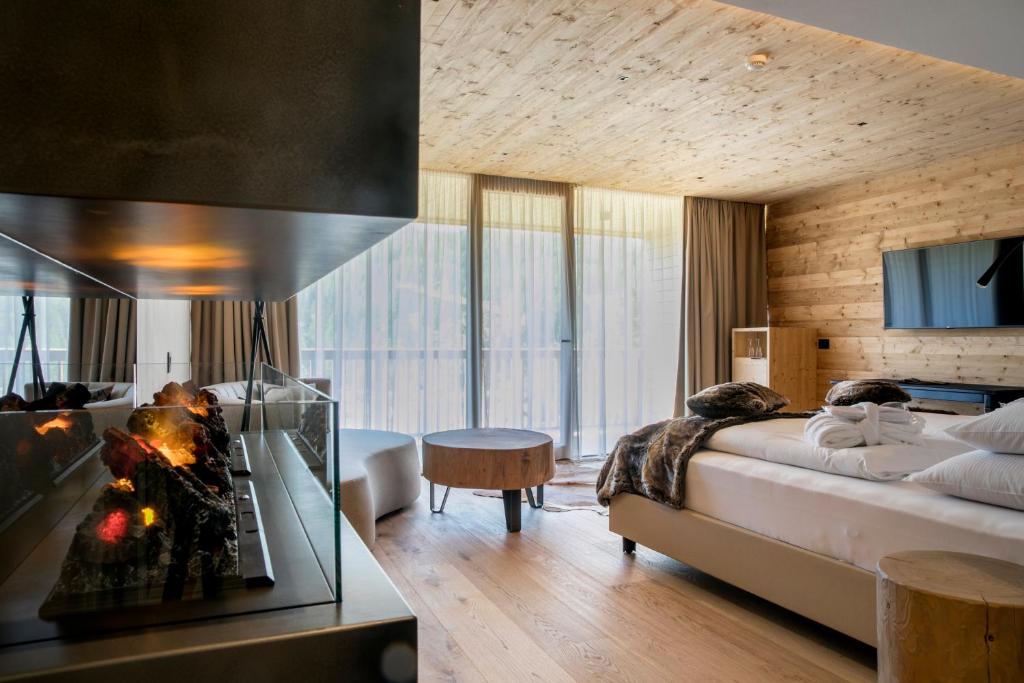 a hotel room with a bed and a fireplace at Hotel Gran Paradiso in San Cassiano