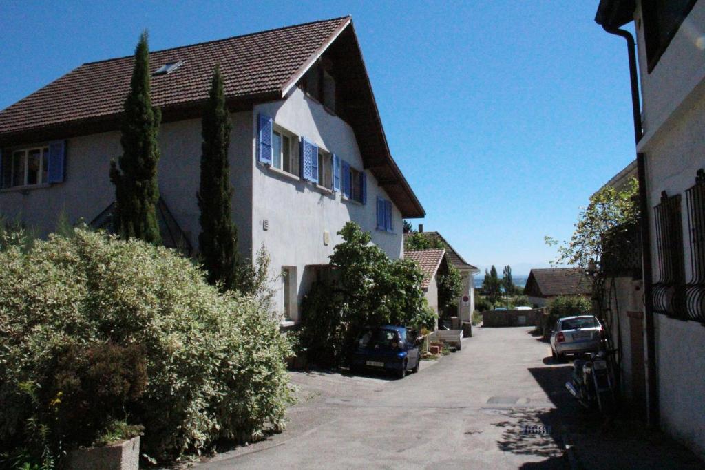 ein Haus mit einem Auto, das an der Straßenseite geparkt ist in der Unterkunft Appartement Les Iris in Bevaix