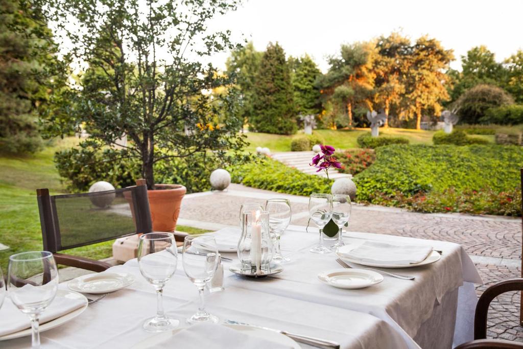 a table with plates and wine glasses on a patio at Cosmo Hotel Torri in Vimercate