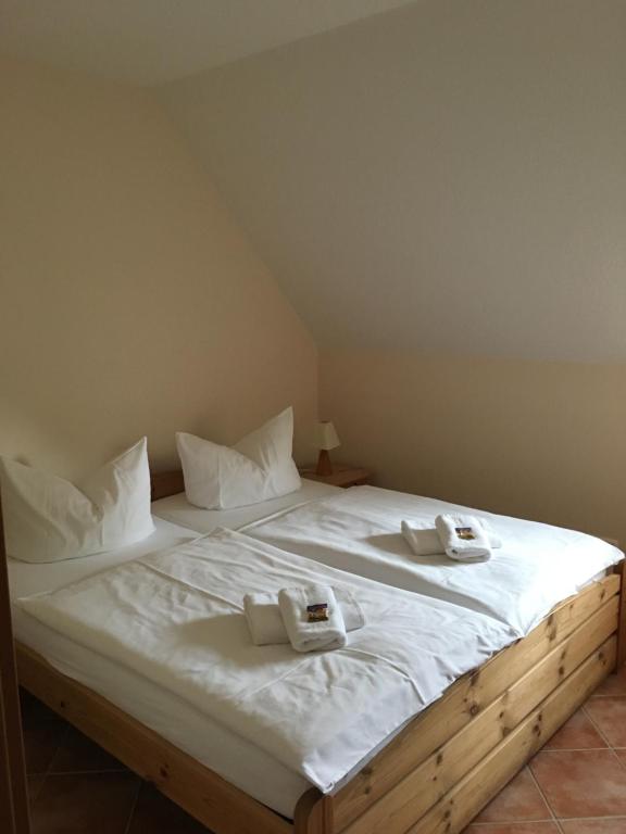 a large bed with white sheets and towels on it at Seerose in Kirchdorf