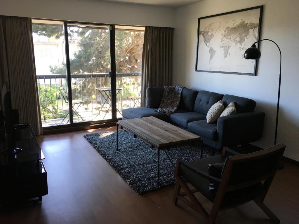 a living room with a blue couch and a coffee table at Twelve Oaks By Marquee Vancouver in Vancouver