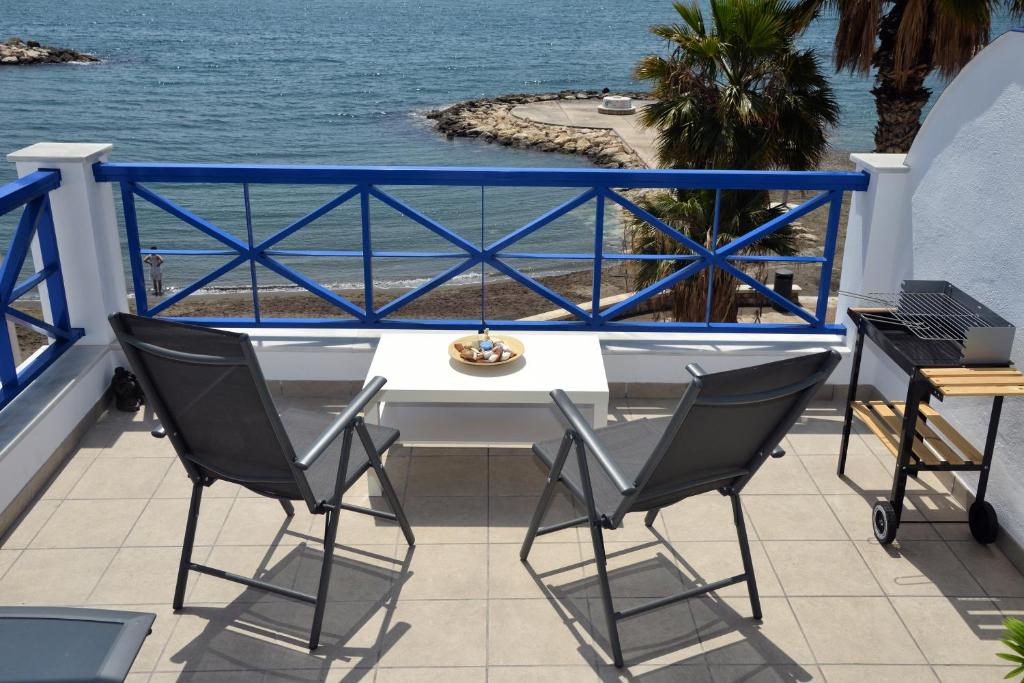 una mesa y sillas en un balcón con vistas al océano en Apartamentos La Perla Azul, en Málaga