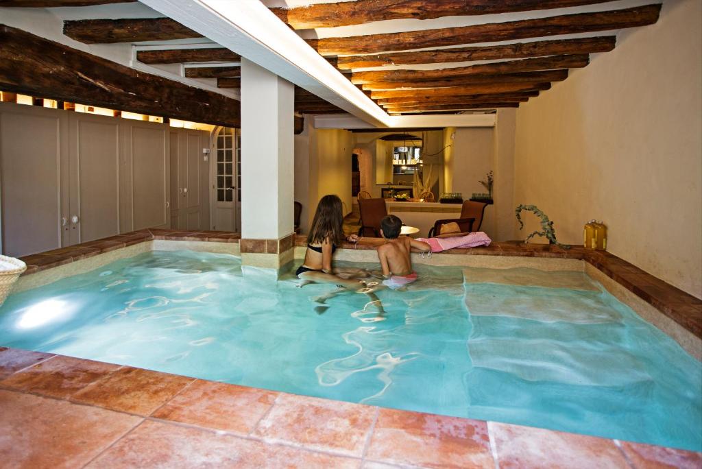 a woman and a child playing in a swimming pool at El Jardinet de Sant Esteve in Olot