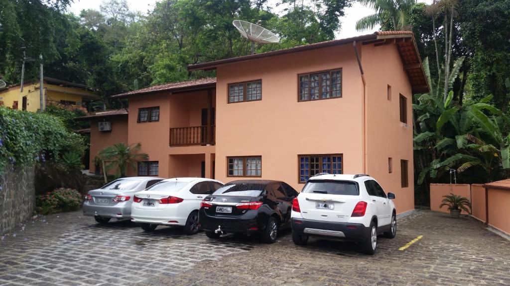 a group of cars parked in front of a house at Chalés e suítes Lourenço in Ilhabela