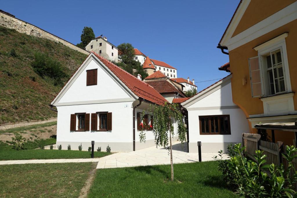 a white house with a hill in the background at Apartment Little house in Ptuj