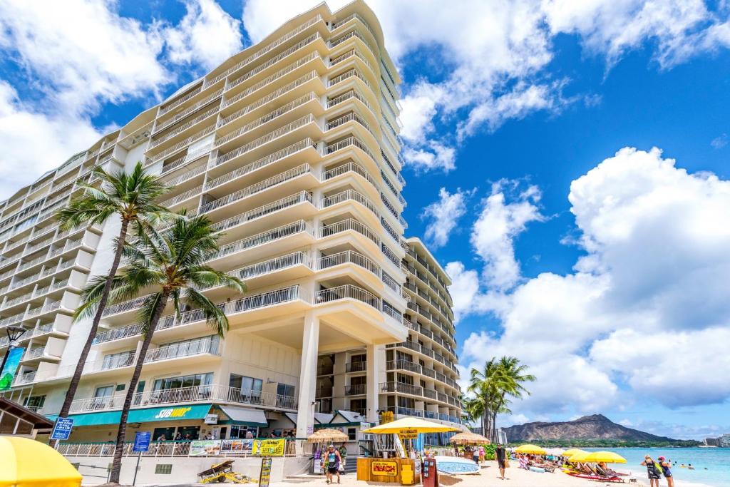 - un grand bâtiment sur la plage avec des palmiers dans l'établissement Waikiki Shore 1116 Beachfront, à Honolulu