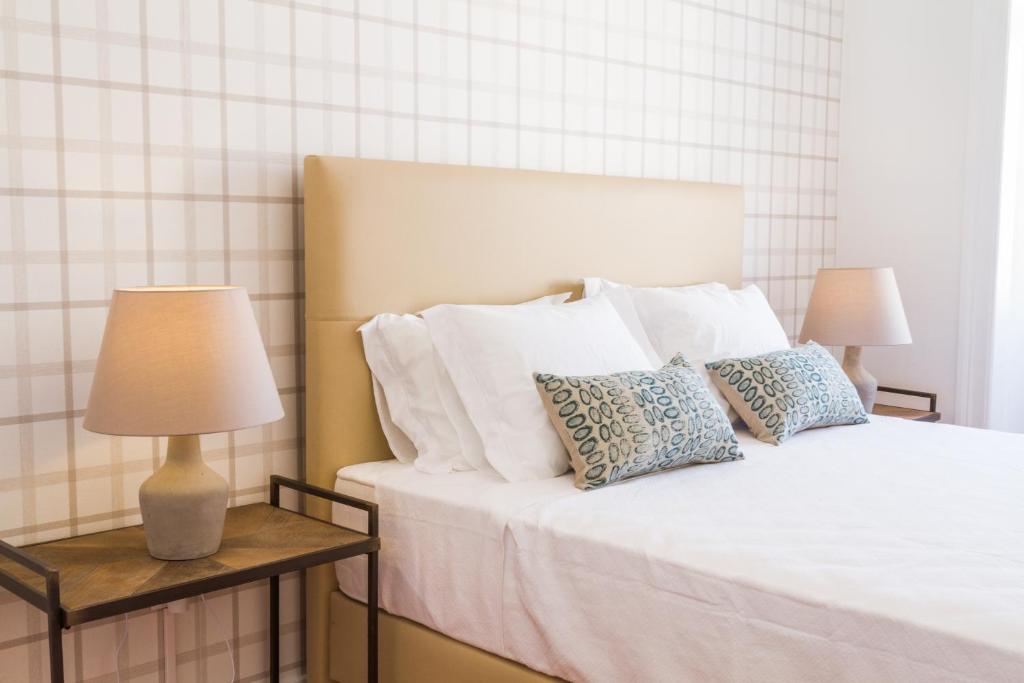 um quarto com uma cama com almofadas e 2 candeeiros em City Lofts Lisbon - Guesthouse em Lisboa