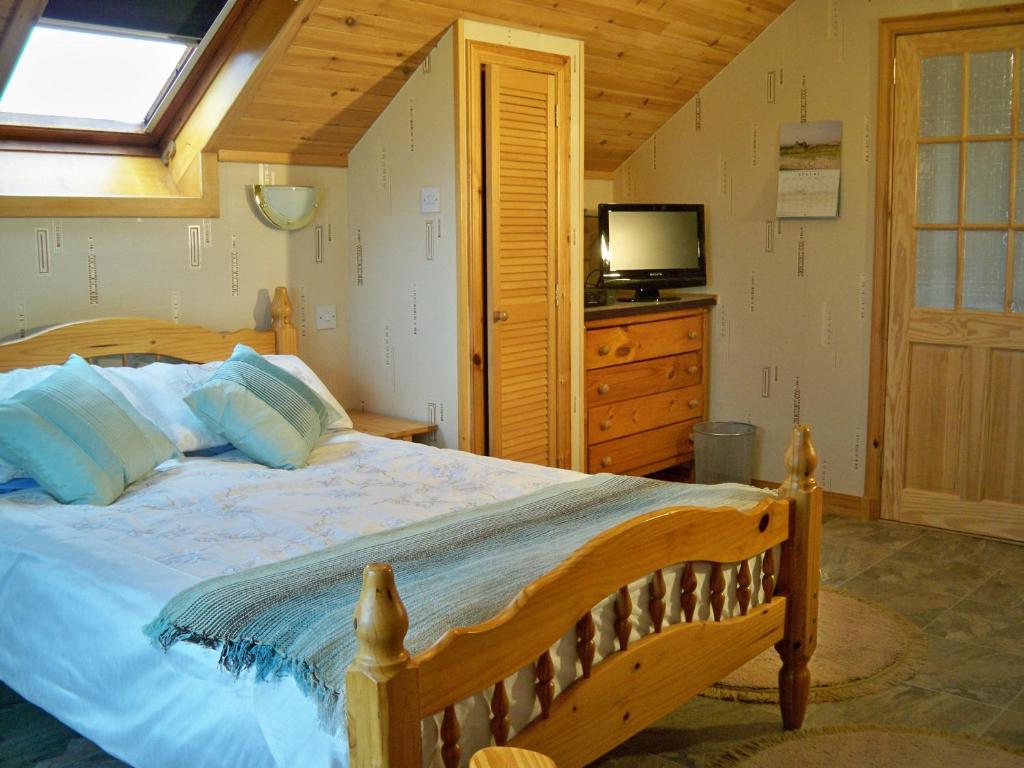 a bedroom with a bed with a television and a dresser at Tamara Apartment in Sandwick