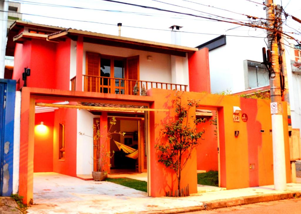 una casa roja y blanca con una puerta abierta en MADÁ hostel, en São Paulo