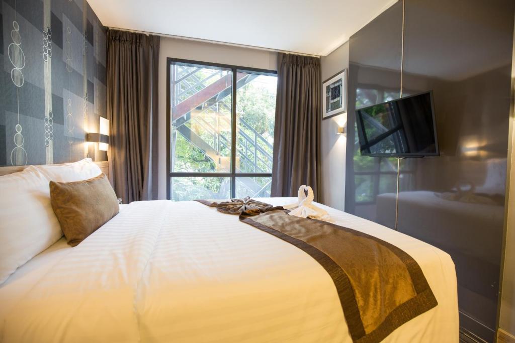 Un dormitorio con una cama grande y una ventana en Aspira Sukhumvit, en Bangkok