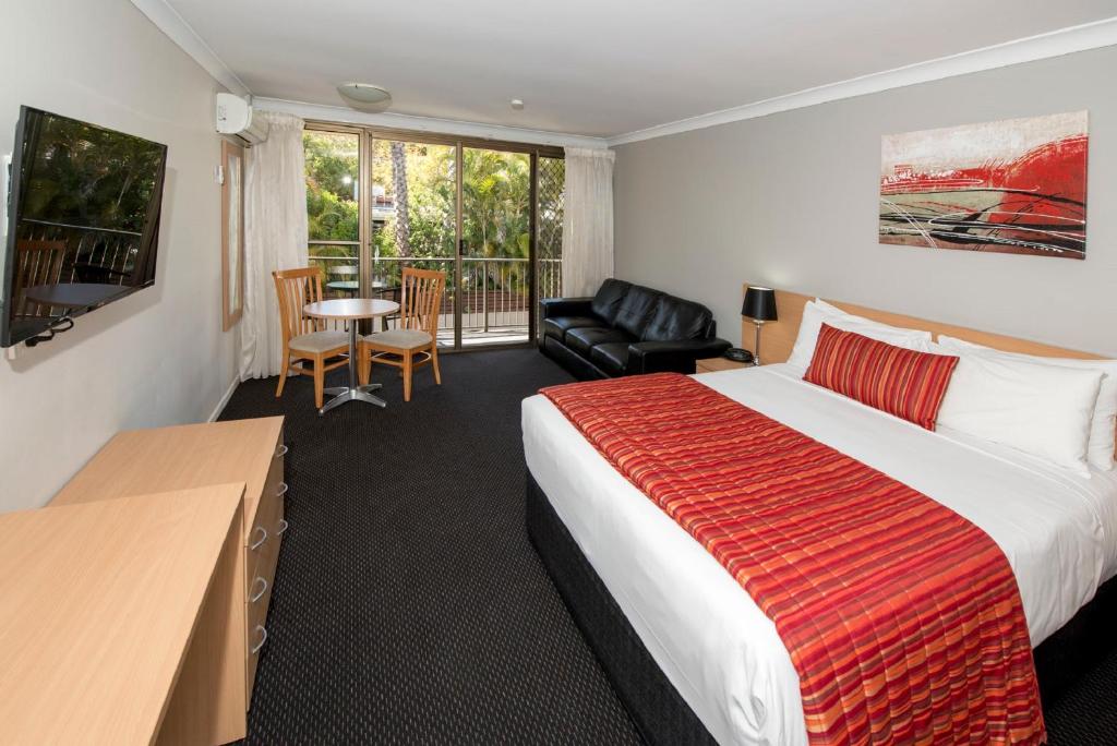 Habitación de hotel con cama grande y balcón. en Comfort Inn Grammar View en Toowoomba