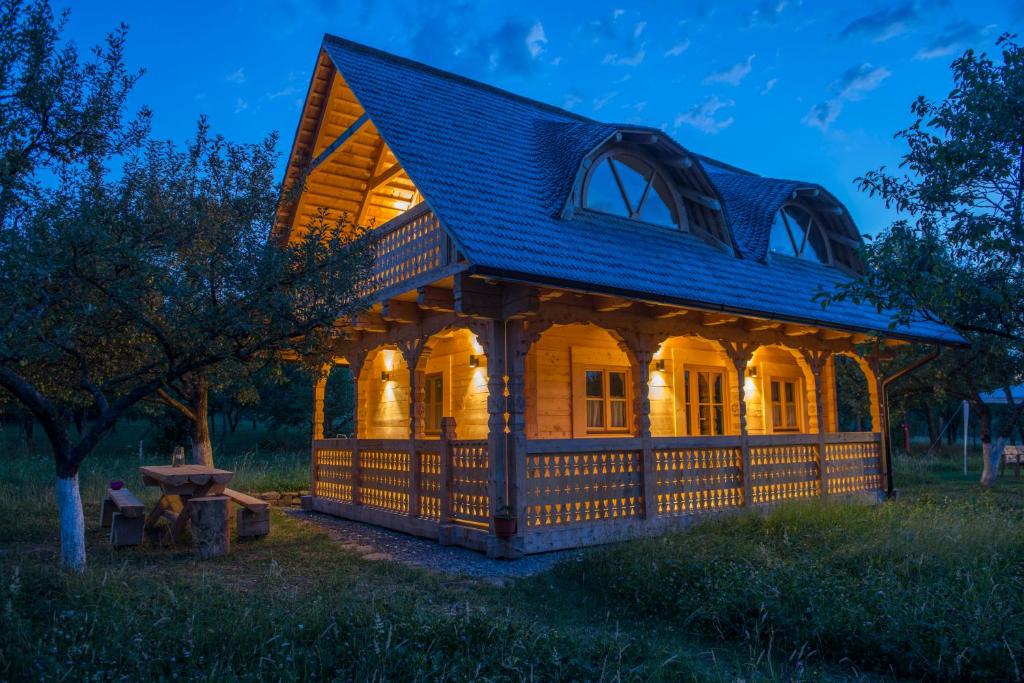 ein Haus mit einer beleuchteten Außenseite in der Nacht in der Unterkunft Magnolia Resort Chalets in Vişeu de Sus