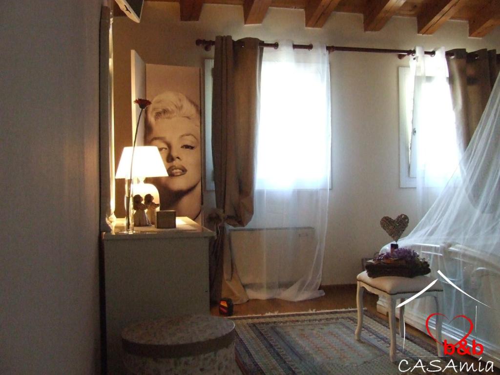 a bedroom with a portrait of a woman on the wall at B&B CASA mia in Sossano