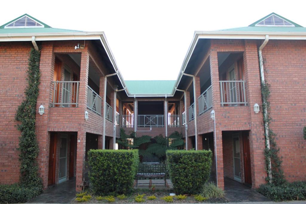 a red brick building with a bench in the courtyard at Mosate Lodge in Polokwane