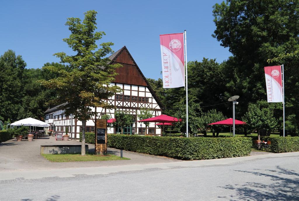 ein Gebäude mit zwei Flaggen davor in der Unterkunft Hotel Restaurant Hof Hueck in Bad Sassendorf