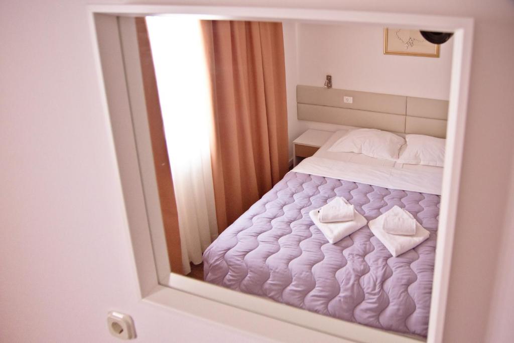a reflection of a bed in a mirror at Hotel No-1 in Međugorje
