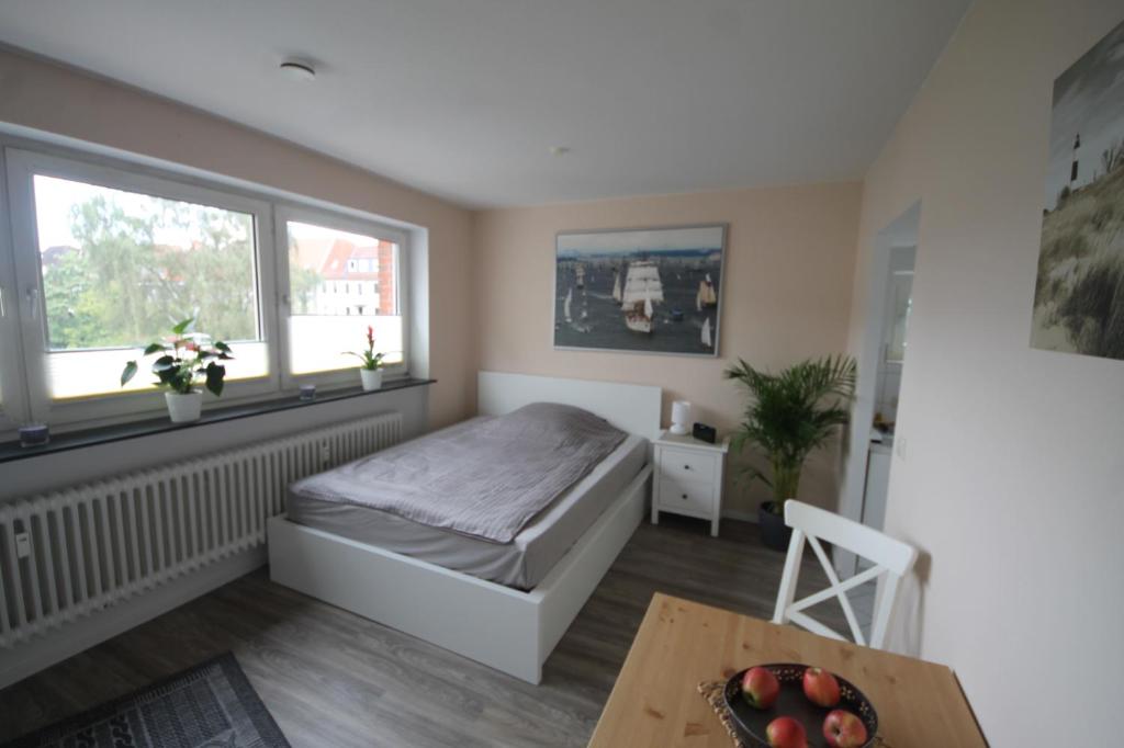 a bedroom with a bed and a table at Apartment am Blücherplatz in Kiel