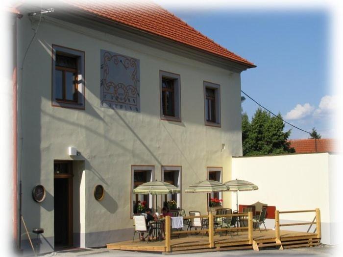 a building with tables and umbrellas in front of it at Penzion Haberský vrch in Habří