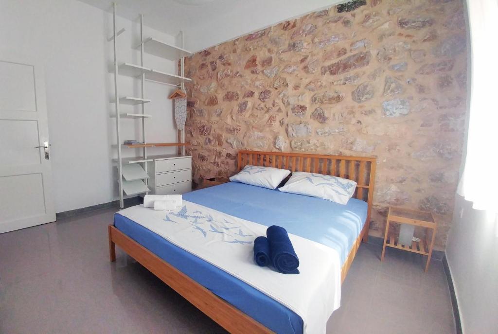 um quarto com uma cama com sapatos azuis em KYMA Apartments - Athens Acropolis 2 em Atenas