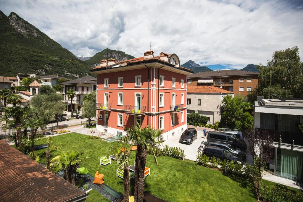 a large pink building in a city with a yard at Holiday IV Gardan in Riva del Garda