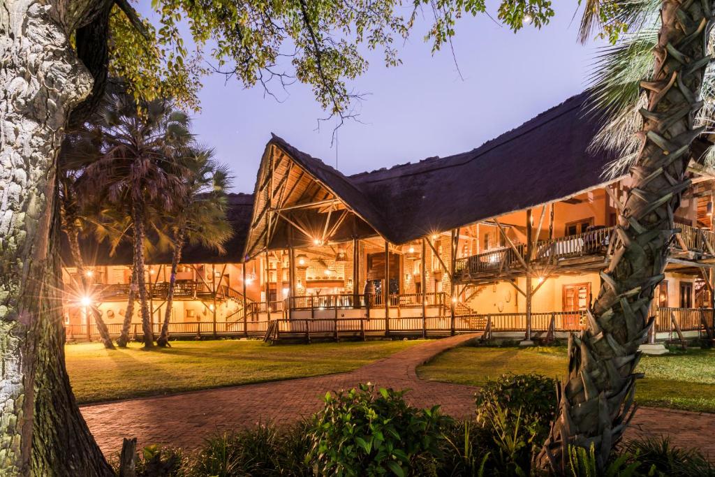 una vista exterior de una casa con una palmera en The David Livingstone Safari Lodge & Spa, en Livingstone