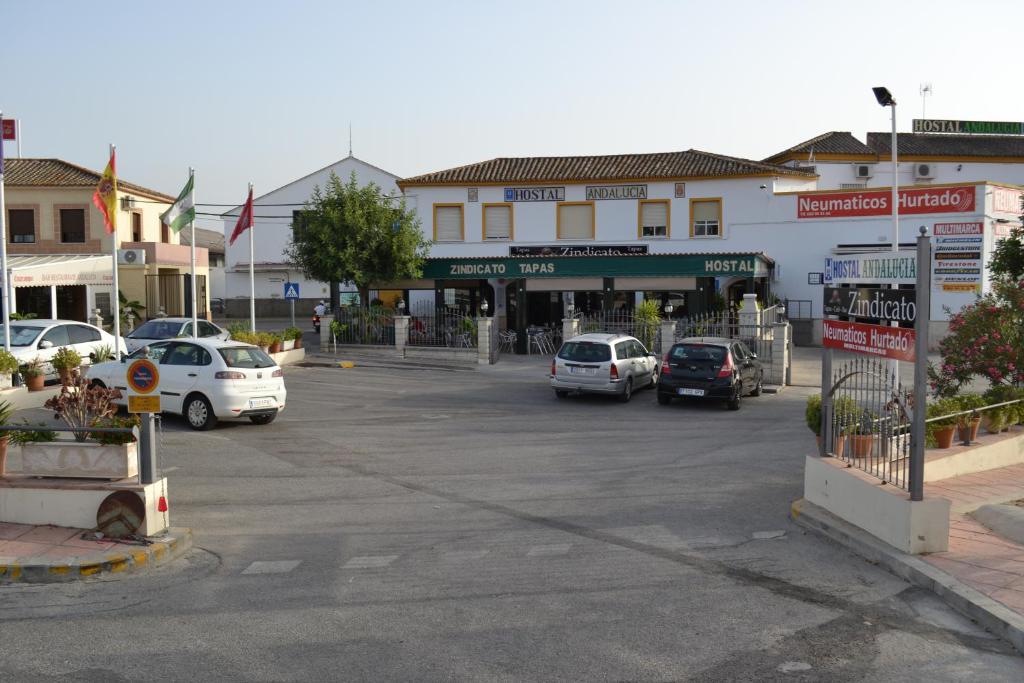 un parcheggio con auto parcheggiate di fronte a un edificio di Hostal Andalucia ad Arcos de la Frontera