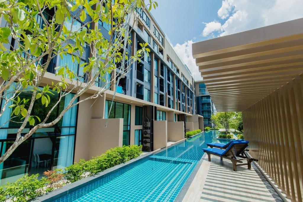 a swimming pool in the middle of a building at The Aristo by Holy Cow, 4-BR loft, 150 m2, pool view in Surin Beach