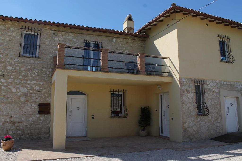 un bâtiment avec un balcon au-dessus dans l'établissement Il casale di famiglia, à Montefalco