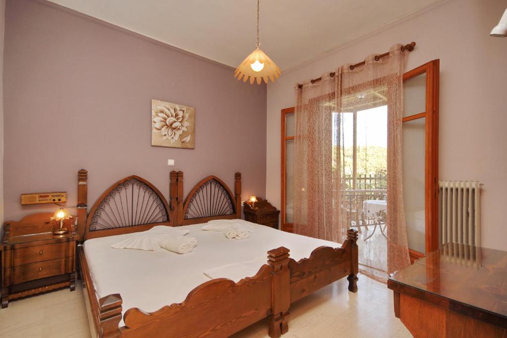 Un dormitorio con una cama grande y una ventana en Hotel Marialena en Ancient Epidavros