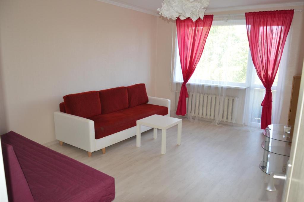 a living room with a red couch and a window at Apartment with Sea View in Liepāja