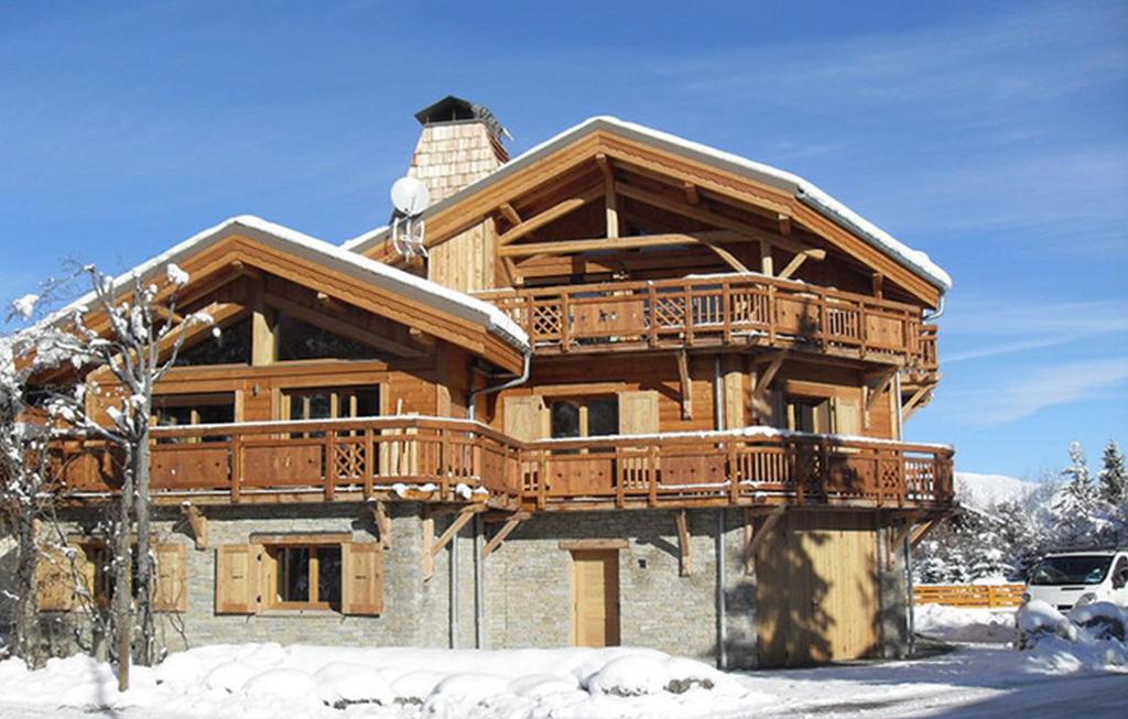 una grande casa in legno con balcone nella neve di Odalys Chalet Levanna Orientale a Les Deux Alpes