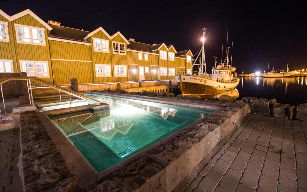 a swimming pool with a boat in the water at Siglo Hotel by Keahotels in Siglufjörður