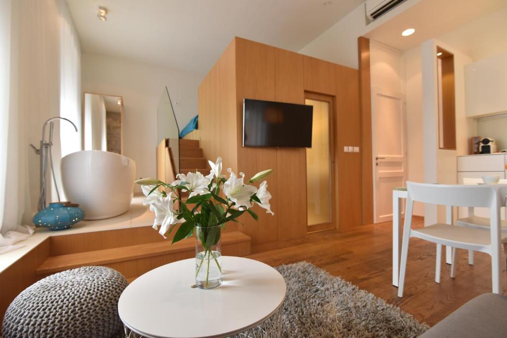 a living room with a vase of flowers on a table at The Bridge Luxury Apartments in Zadar