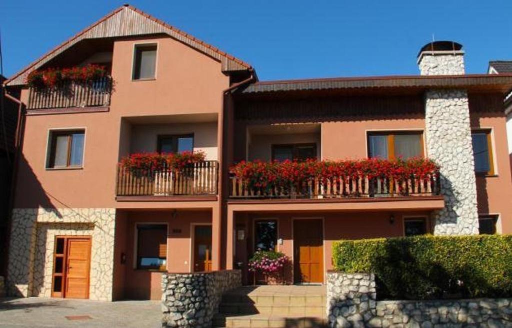 una casa grande con flores en los balcones en Penzion Vinařský dům PÁLAVA, en Strachotín