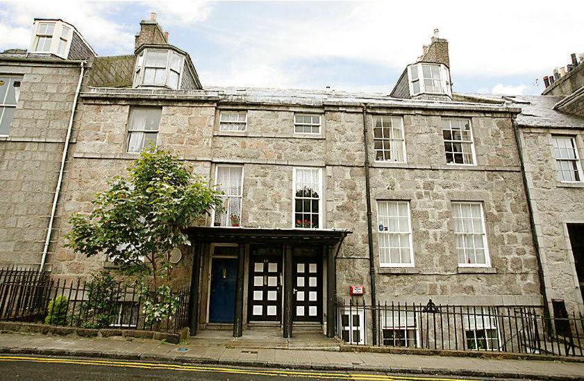 um antigo edifício de pedra com uma porta numa rua em Skene Terrace Apartments em Aberdeen
