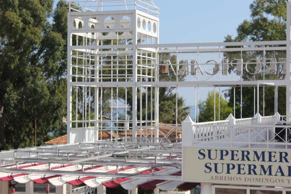 un edificio bianco con un cartello davanti di Apartamento Tropicana a Denia